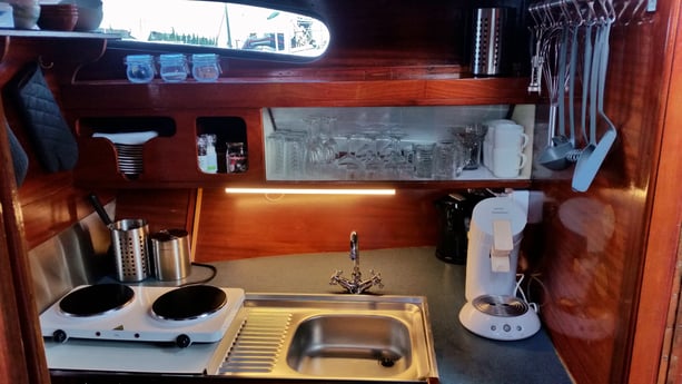 A modest kitchen fully equipped with coffee machine, water cooker, small cooking facilities, etc.